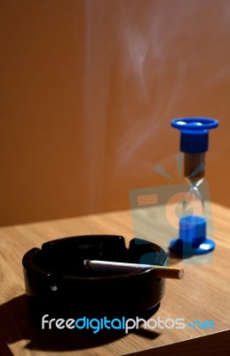 Ashtray With Cigarette And Hourglass Stock Photo