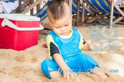 Asian Boy Playing Sand On The Beach Stock Photo