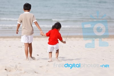 Asian Boys Holding Hands On Beach Stock Photo