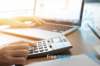 Asian Business Woman Using A Calculator To Calculate The Numbers… Stock Photo