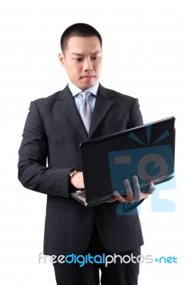 Asian Businessman Holding Laptop Stock Photo