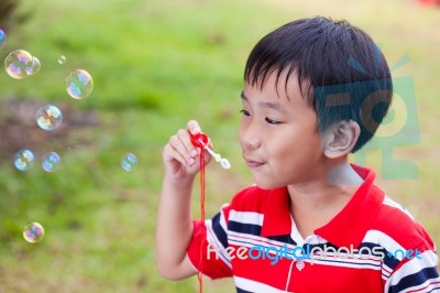 Asian Child Blowing Soap Bubbles In Summer Park, Nature Backgrou… Stock Photo