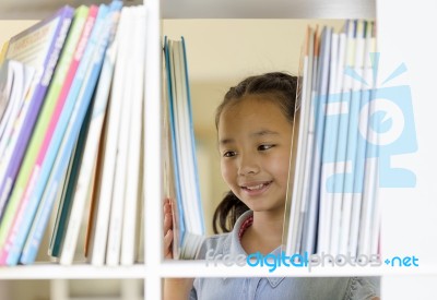 Asian Children Choosing A Book In The Library Stock Photo