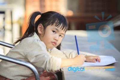 Asian Children With Yellow Pencil In Hand Doing School Home Work With Happiness Emotion Stock Photo