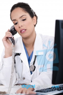 Asian Female Doctor Talking Over Phone Stock Photo