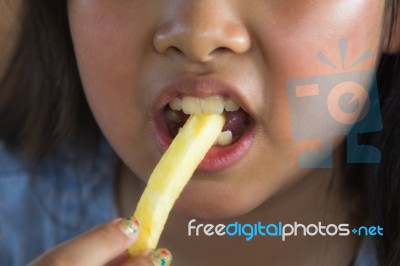 Asian Girl Eating French Fries Stock Photo