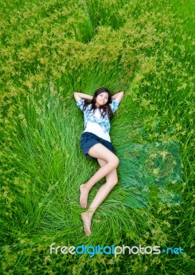 Asian Girl Laying On Green Meadow Stock Photo