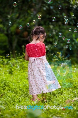 Asian Girl Playing With Soap Bubbles On Nature Background. Outdoors Stock Photo