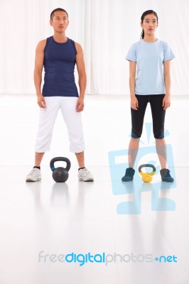 Asian Man And Woman Doing Kettle Bell Crossfit Exercise Stock Photo