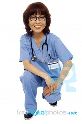 Asian Surgeon Squatting Down Stock Photo