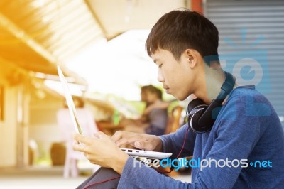 Asian Teenager Using Laptop  Stock Photo