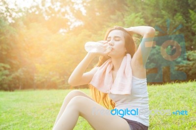 Asian Woman Are Drinking And Sitting On The Lawn Stock Photo