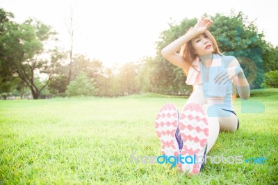 Asian Woman Are Tired Sitting On The Lawn Stock Photo