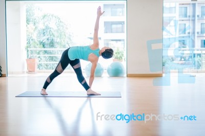 Asian Woman Doing Yoga Indoors Stock Photo