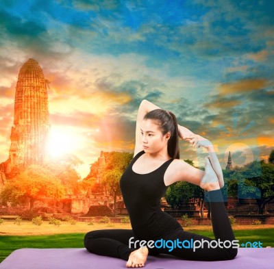 Asian Woman Health Care Yoga Posting With Asian Ancient Pagoda Temple And Sun Set Sky Stock Photo