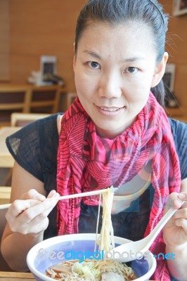 Asian Woman Is Eating Noodles Stock Photo