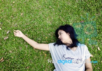 Asian Woman Laying In The Grass Stock Photo