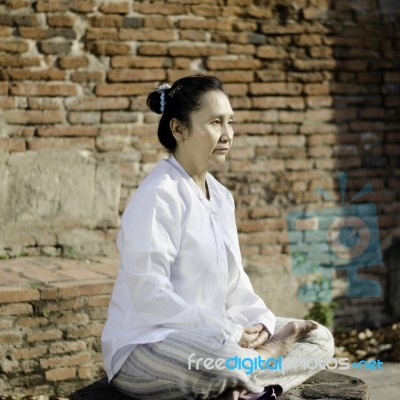 Asian Woman Meditating In Ancient Buddhist Temple Stock Photo