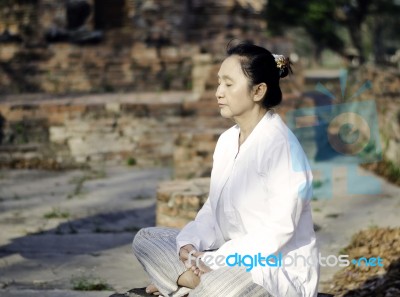 Asian Woman Meditating In Ancient Buddhist Temple Stock Photo