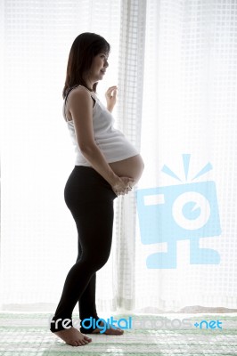 Asian Woman Pregnant ,pregnancy Standing In Home Room Against Wh… Stock Photo