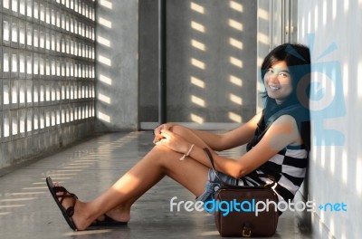 Asian Woman Sitting On Corridor Floor Stock Photo