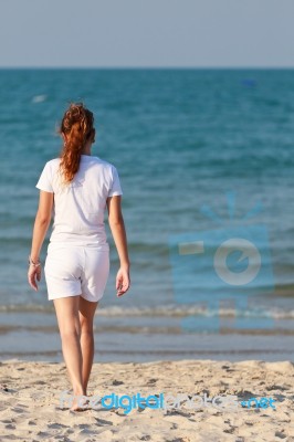 Asian Woman Walking On Beach Stock Photo