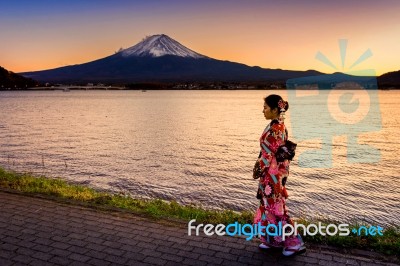 Asian Woman Wearing Japanese Traditional Kimono At Fuji Mountain. Sunset At Kawaguchiko Lake In Japan Stock Photo