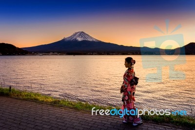 Asian Woman Wearing Japanese Traditional Kimono At Fuji Mountain. Sunset At Kawaguchiko Lake In Japan Stock Photo