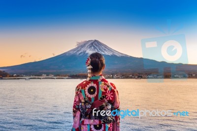 Asian Woman Wearing Japanese Traditional Kimono At Fuji Mountain. Sunset At Kawaguchiko Lake In Japan Stock Photo