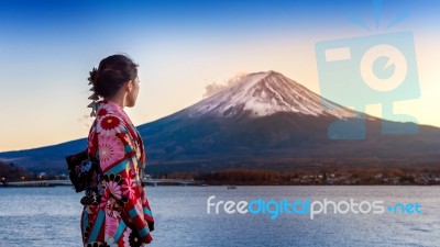 Asian Woman Wearing Japanese Traditional Kimono At Fuji Mountain. Sunset At Kawaguchiko Lake In Japan Stock Photo