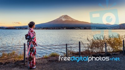 Asian Woman Wearing Japanese Traditional Kimono At Fuji Mountain. Sunset At Kawaguchiko Lake In Japan Stock Photo