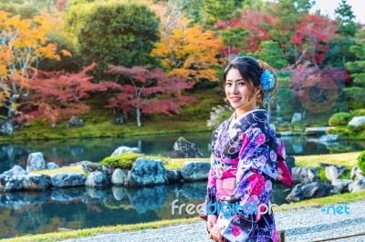 Asian Woman Wearing Japanese Traditional Kimono In Autumn Park. Japan Stock Photo