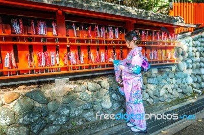 Asian Women Wearing Japanese Traditional Kimono Visiting The Beautiful In Fushimi Inari Shrine In Kyoto, Japan Stock Photo