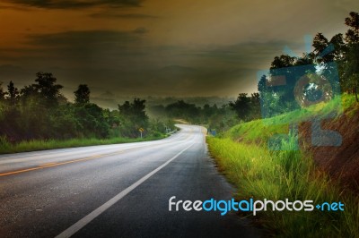 Asphalt Road Run Into The Mountain In Morning Light With Little Stock Photo