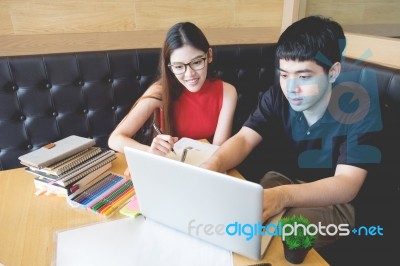 At Home, Two Students Working On A Project On A Laptop, The Atmo… Stock Photo