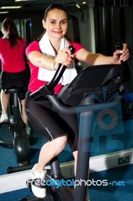 Athletic Woman Cycling At The Gym Stock Photo