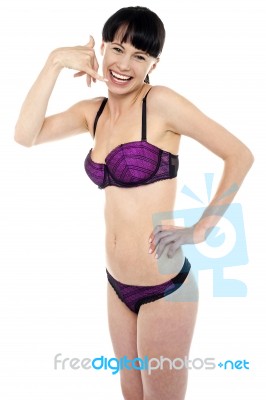 Attractive Brunette In Bikini Gesturing A Mock Call Stock Photo