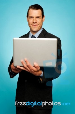 Attractive Businessman Holding Laptop Stock Photo