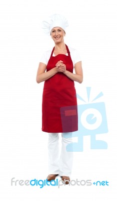 Attractive Female Chef In Red Apron And Toque Stock Photo