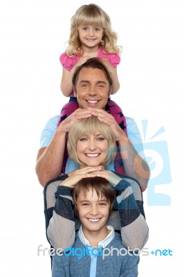 Attractive Smiling Family Of Four Posing In A Single Line Stock Photo