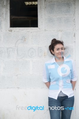 Attractive Teenage Asian Girl Standing In Front Of Grunge Concrete Wall Stock Photo