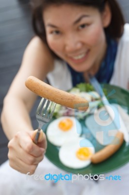 Attractive Woman Giving A Sausage Stock Photo