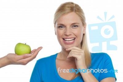 Attractive Woman Is Being Offered A Green Apple Stock Photo