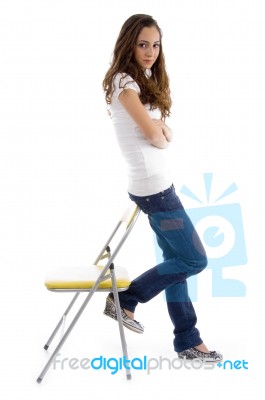 Attractive Young Female Standing With Support Of Chair Stock Photo