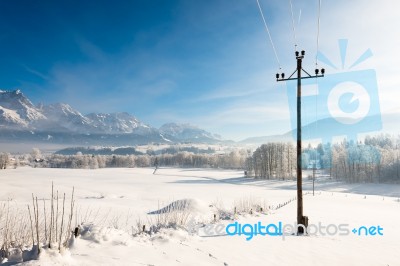 Austrian Winter Wonderland With Mountains, Fresh Snow And Haze In The Sunlight Stock Photo