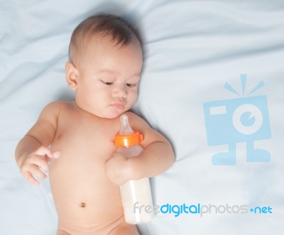 Baby Boy Holding Milk Bottle Stock Photo