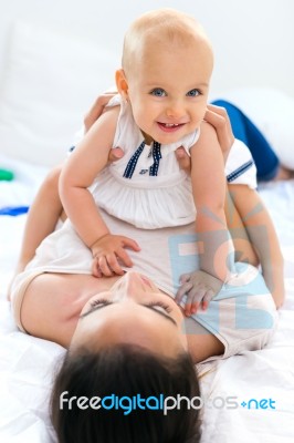 Baby Girl And Her Mother Playing At Home Stock Photo