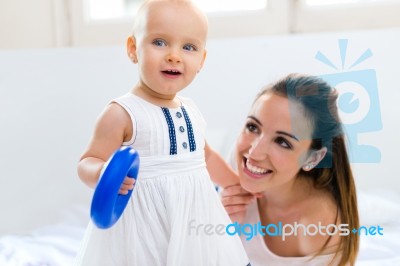 Baby Girl And Her Mother Playing At Home Stock Photo