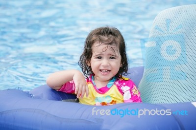 Baby Girl Floating In Swimming Pool Stock Photo