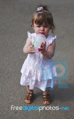 Baby Girl Sipping From A Cup Stock Photo